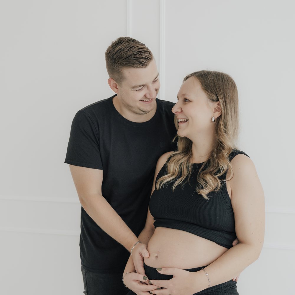 Paar hält den Babybauch gemeinsam