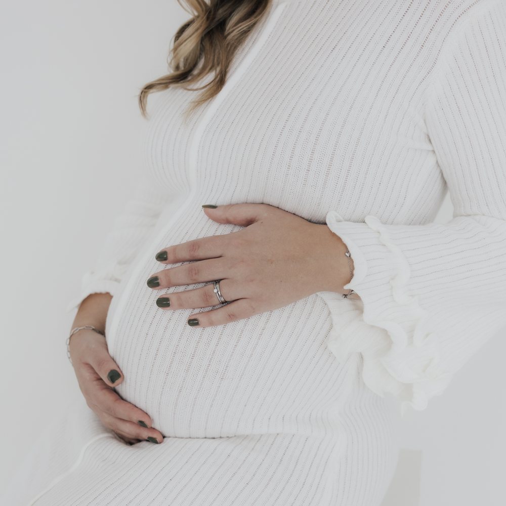 Babybauch-Detail mit Hand