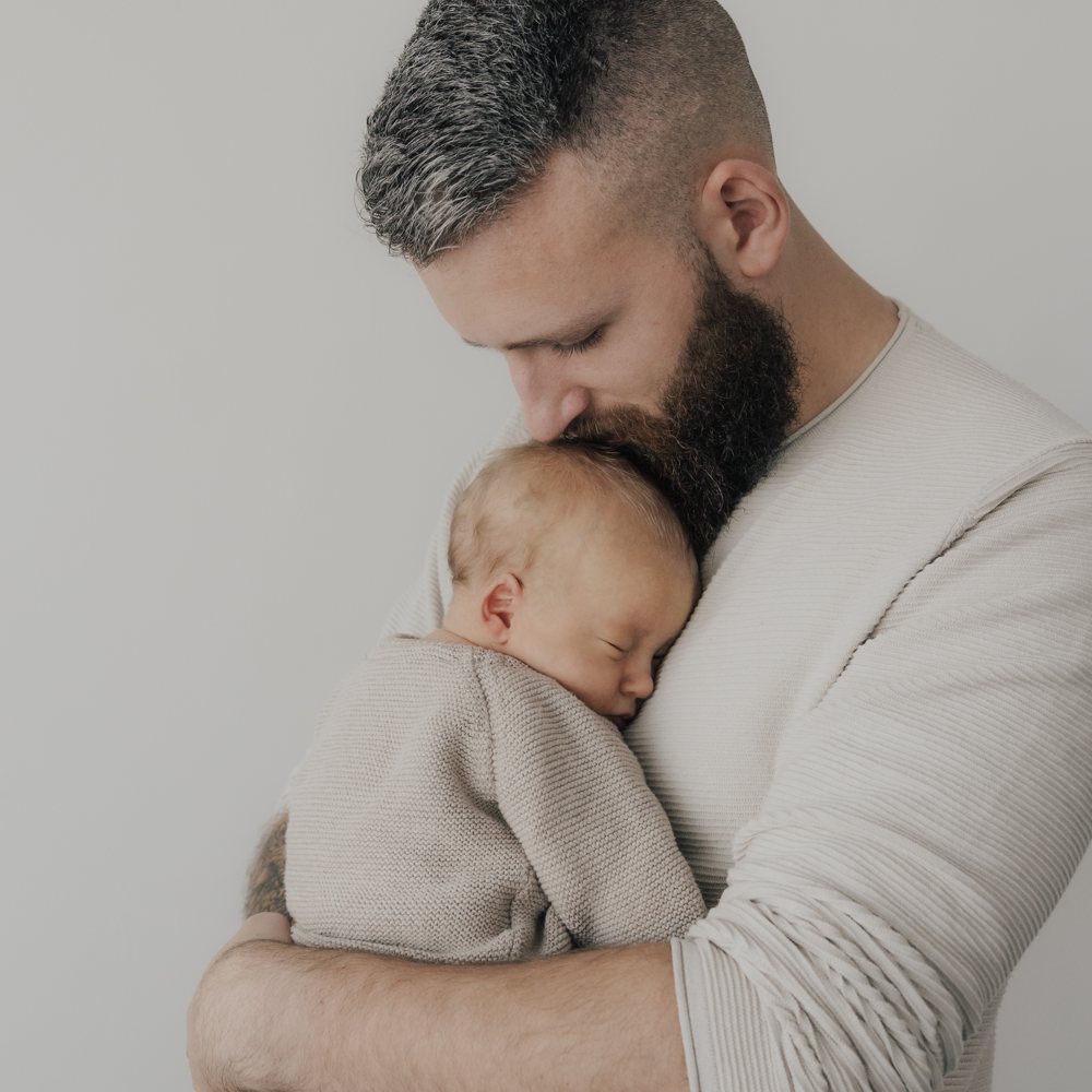 Papa mit Neugeborenem im Arm