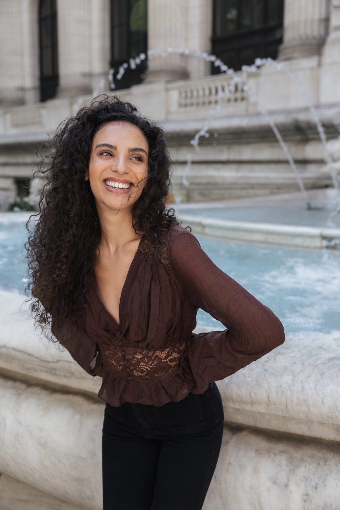 Model lächelnd vor dem Brunnen