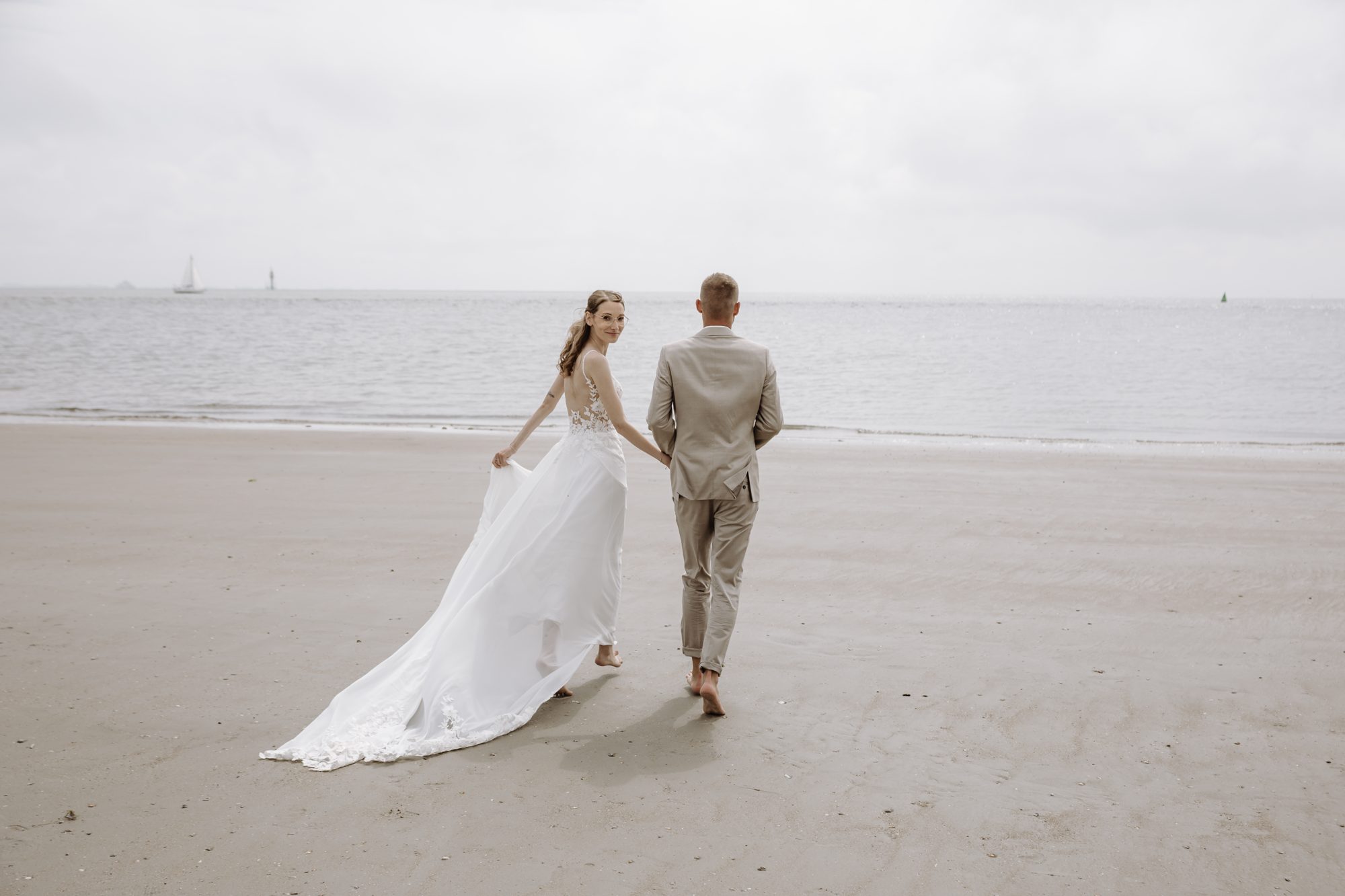 Brautpaar am weiten Sandstrand an der Nordsee