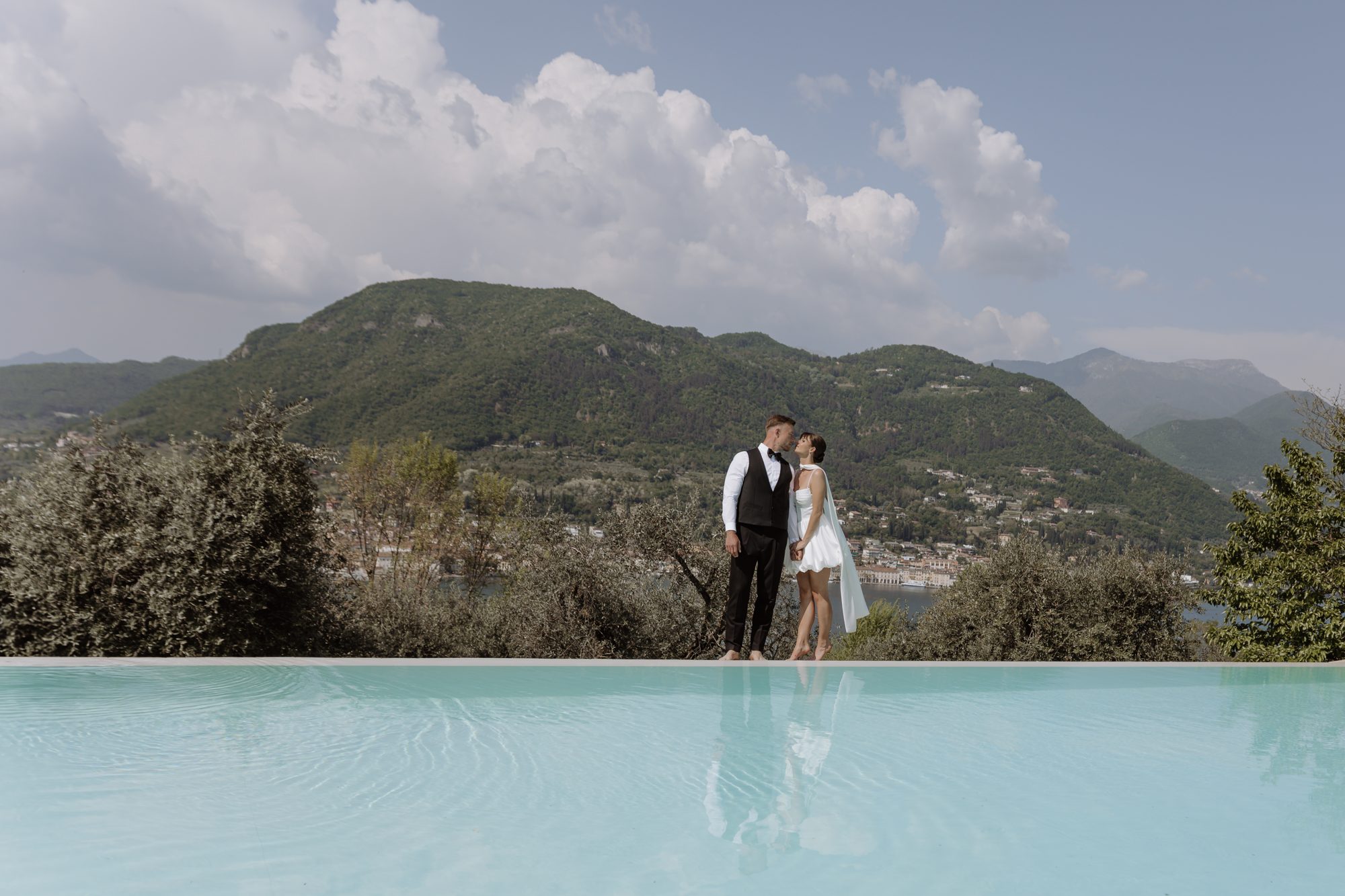 Brautpaar an einem Pool mit Blick über die Berge in Italien