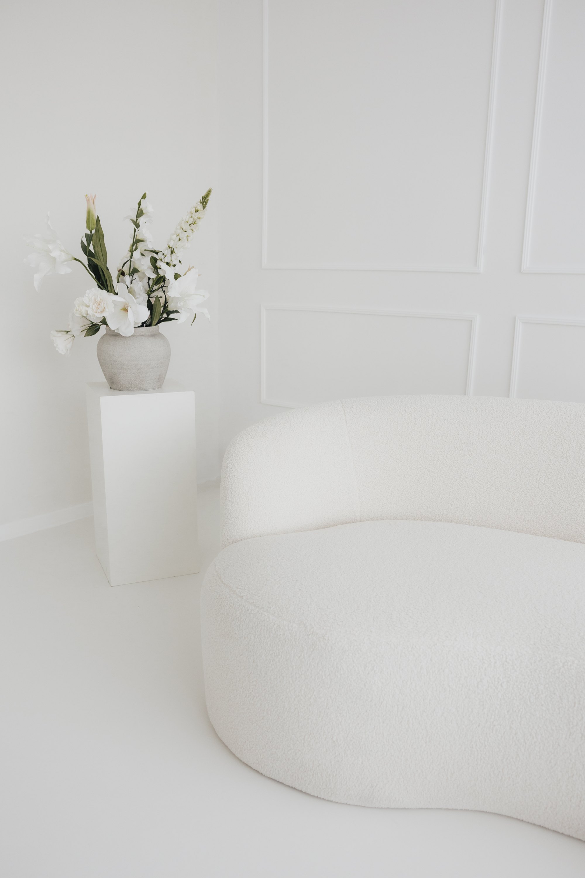 Helles Tageslichtstudio in Sande mit Bouclé-Sofa und Blumen
